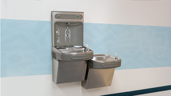 Metallic school water-filling station and water fountain side by side in hallway.
