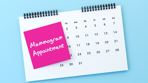 Calendar opened to a month with 31 days and sticky note reading “Mammogram Appointment.”