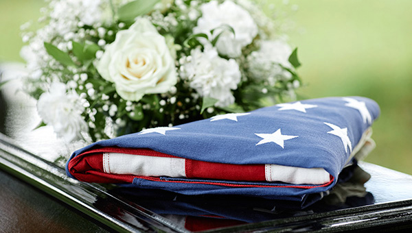 Burial Benefits: American flag on coffin with flowers