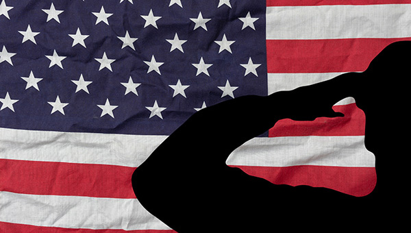 Veterans Benefits: Soldier saluting on USA flag