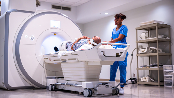 Patient on stretcher being put into an MRI machine by medical technician