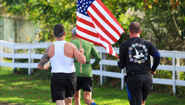 Man carrying an American flag running race