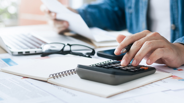 Investors are calculating profits and costs with calculators, growth and investment chart analysis, business planning and strategies to maximize sales profits. Long term business plan.