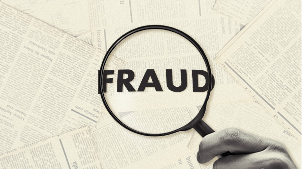 Magnifying glass over documents highlighting the word “Fraud.”