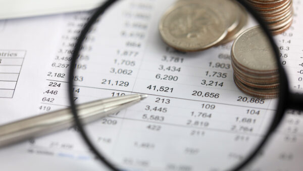 View at financial details in table thru magnifying glass close-up