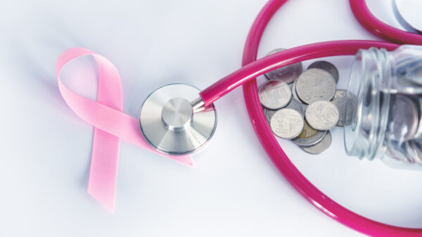 Breast Cancer Health insurance and Money saving for Medical Healthcare disease insurance concept , coin money jar with stethoscope and pink ribbon on white background