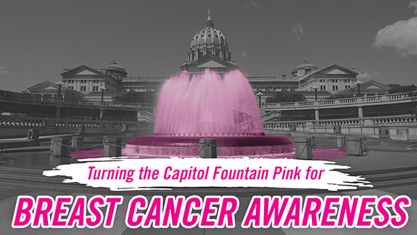 Exterior of PA Capitol in black and white, with water fountain and pink words reading “Turning the Capitol Fountain Pink for Breast Cancer Awareness.”