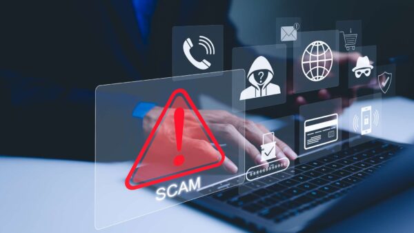 Warning symbol with the word ‘Scam’ over a laptop as digital security icons appear around the screen.